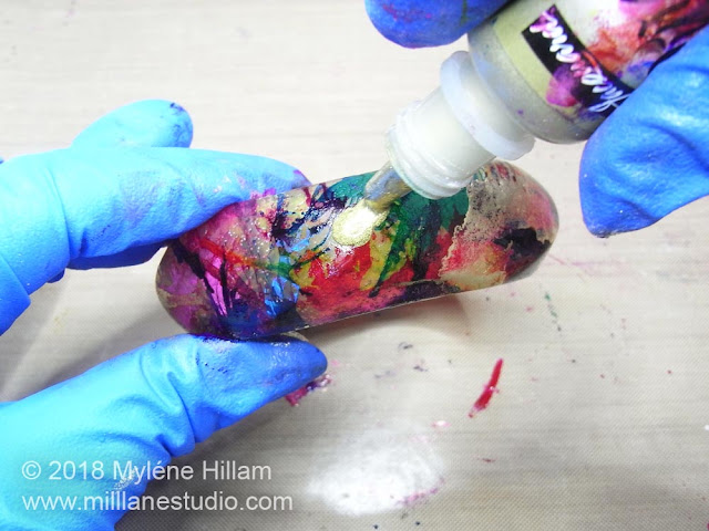 Adding drops of gold alcohol ink onto the dried colours and allowing it to run.