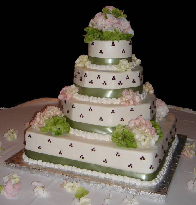 Four tier multi shaped wedding cake with green trimming and light pink and 