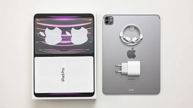 "2024 iPad Pro with its packaging, USB-C charger, and USB-C cable neatly displayed on a white surface.