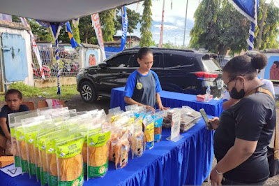 Seorang warga Papua Barat gunakan QRIS saat belanja di bazar.