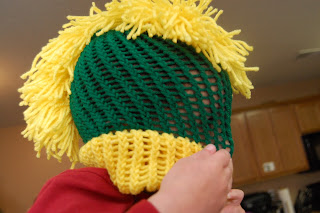 boy playing with a knit mohawk hat