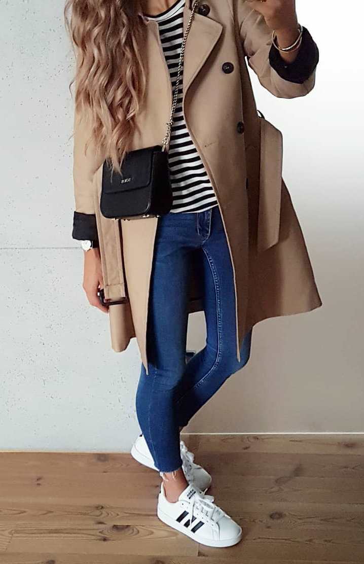 trendy fall outfit idea for this season / striped top + black bag + nude coat + skinny jeans + sneakers