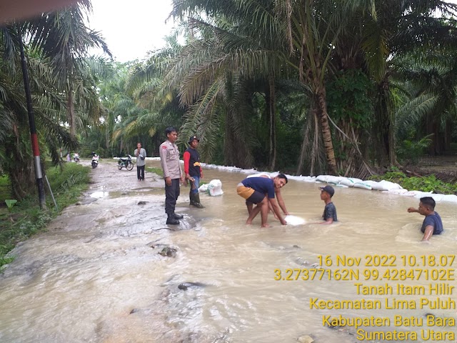 Bhabinkamtibmas Polsek Limapuluh Bantu Warga Desa Tanah Hitam Yang Mendapat Banjir Kiriman 