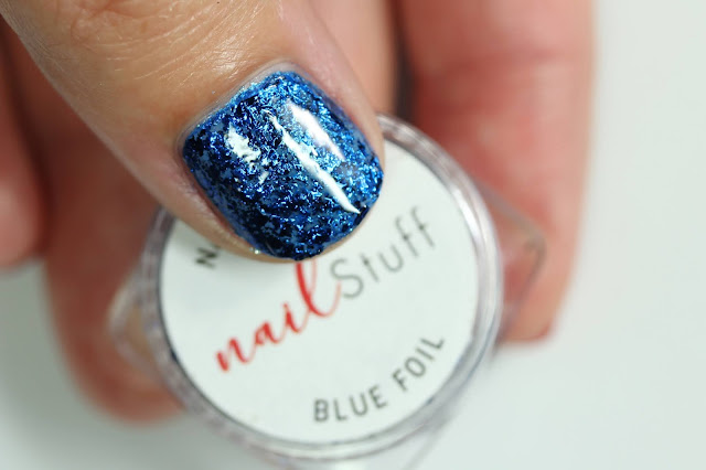 Blue Metallic Nail Flakes from NailStuff shown over blue nail polish on one nail 