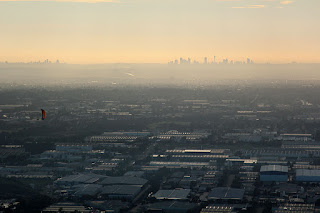 Nucleon doing wingovers with the skyscrapers on the horizon