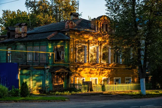 Старое деревянное здание с декором в лучах закатного Солнца