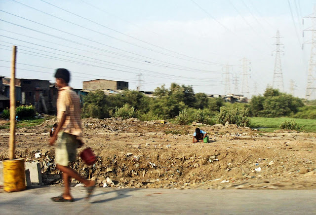 people shitting on road-side