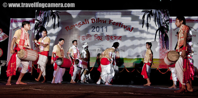 Huchori Performance by an Assamese group of boys @ Rongali Bihu Festival, IGNCA, Delhi : Posted by VJ SHARMA on www.travellingcamera.com : Huchori - Huchori is an integral part of Rongali Bihu. Choral parties of singers and dancers moving from house to house is a salient feature of Rongali Bihu !!!Huchori is a regular thing which happens during the Rongali Bihu and it is a custom of community singing in which a group of singers visit each home in their locality and sing songs containing spiritual and moral values. The group comprises only of men and the event coincides with the Assamese New Year. The group visits every house irrespective of caste, creed and social status of the householder. During the reign of the Ahom dynasty, Huchori singing was a usual custom in the royal palaces. At a later period it began to be practiced by common people.A group of boys performed Hichuri on the stage and it was really interesting to see overall getup of folks in the groups and it seems elder folks also join this group to better guide the younger ones :) .. Although I was not able to make any sense out of the songs or dialogs, but it looked very interesting !!!Huchori group begins its procession from the village headman’s house and continue towards the other houses in the vicinity. The procession proceeds amidst chanting, singing and dancing. Visiting each house in the village, the group accepts some donation from the residents. The singers usually carry a staff, a bag, an umbrella and a lamp while roaming around the village. Their instruments comprise of dhol (drum), taal (cymbals), pepa (horn pipe) and taka (bamboo clapper).This seems more like Lohri in North India.. Specially in Punjab and Himachal Pradesh !!! On Lohri week, boys make some groups and start visiting various houses in the village/town and sing different Lohri Songs... After that every house master offer some stuff like wheat, corns or rice.. and now people prefer to give money.. as it's convenient for both parties :)Huchori Performance at Rongali Bihu Festival in Indira Gandhi National Center of Arts was amazing and the energy level of folks performing was commendable !!!Here is one of the most enthusiatic performer of Hichori Dance who was handling dhol during Riganli Bihu in Delhi !!!Notice the dressed of all these folks and they have taken proper care of clothings they should use !!!Although I was not able to make out anything as they were singing in Assamese but their expressions were telling a story !! Here a couple is presenting something for god and praying for good !This whole event was organized by Assam association Delhi in partnership with Indira gandhi National Center of Art and it was wonderful experience at Rongali bihu festival !!!