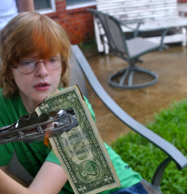 child burning a one dollar bill