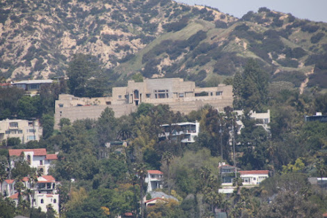 Photo of an enormous house with complex massing in the Los Feliz Hills. Below and around it are a number of smaller, but still large houses.