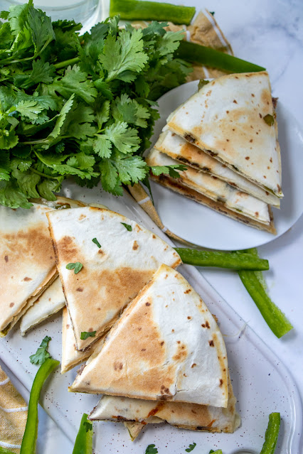 Philly Cheesesteak Quesadillas on a platter and plate with parsley garnish