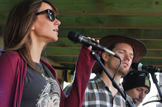 Two singers and a third person playing at microphones