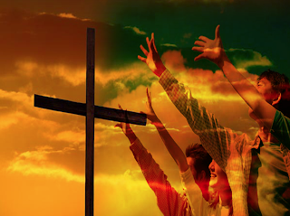 People praising with arms outstretched toward the cross