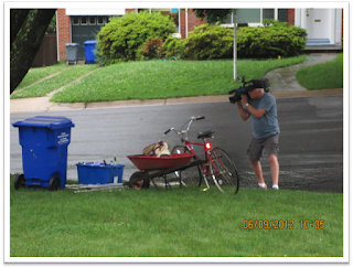 Videographer Mike Springirth aiming camera on scrap metal at curb