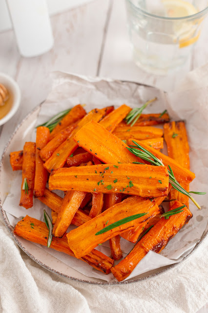 carrots piled on a white plate with a white napkin underneath.