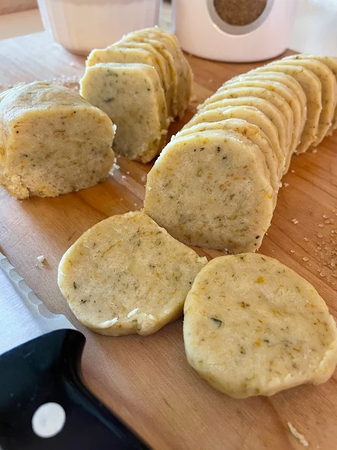 Honey dandelion shortbread cookie log being sliced for baking.