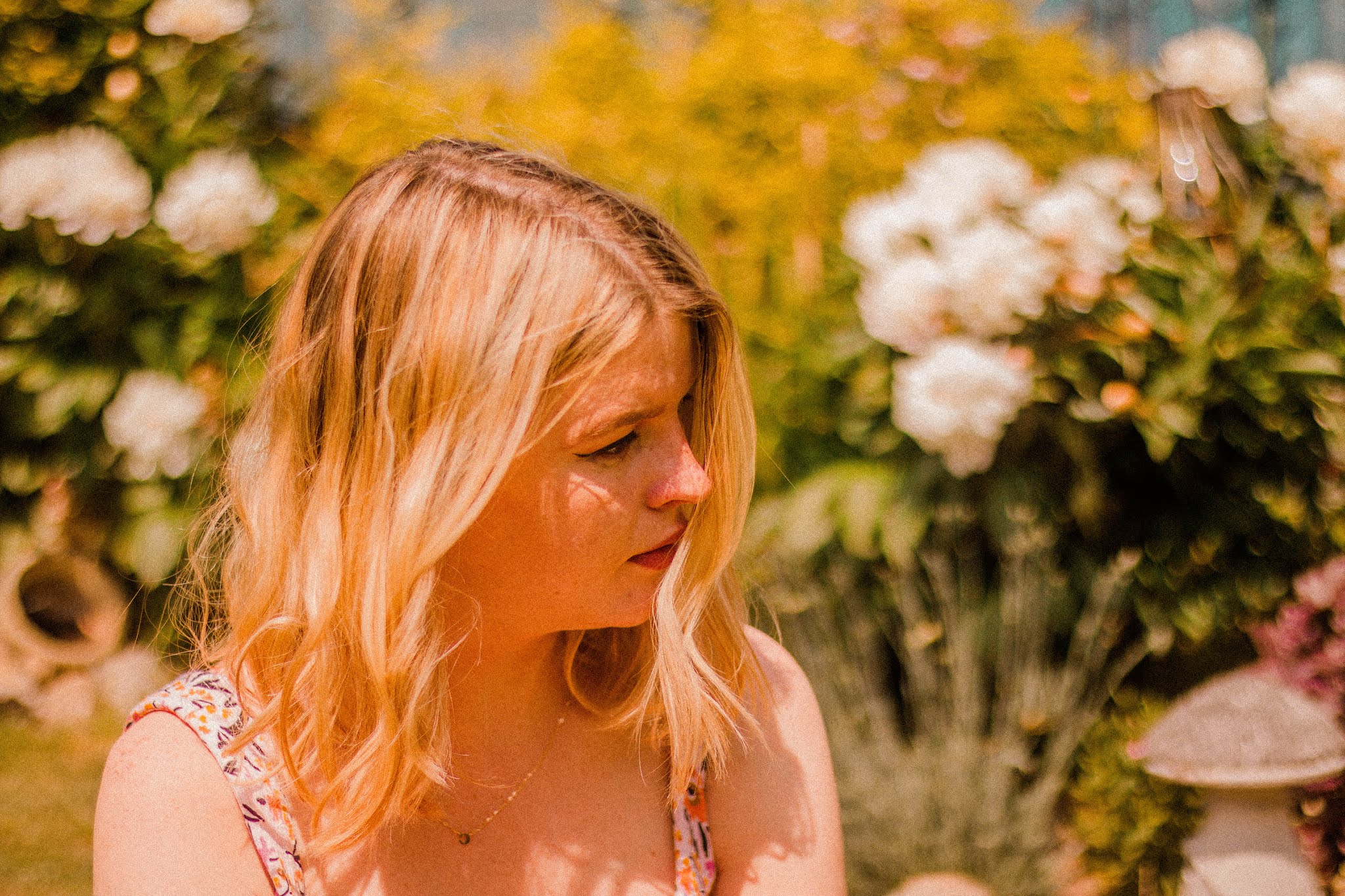 blonde girl in garden wearing floral playsuit - summer bucket list