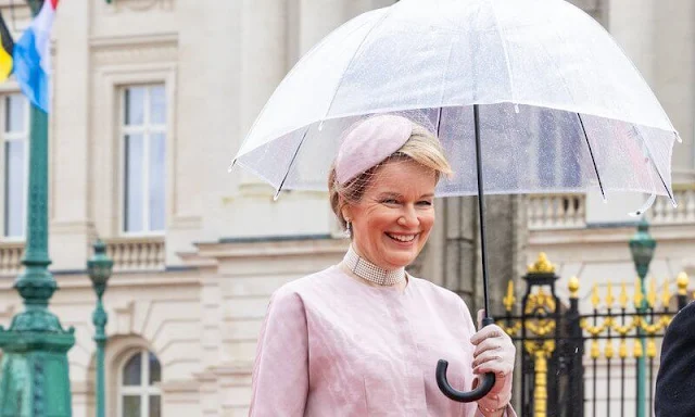 Grand Duchess Maria Teresa wore a blue boucle coat by Dries Van Noten. Queen Mathilde wore a pale pink dress by Natan