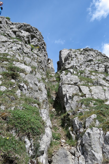 A narrow cleft in the rock, providing a scrambling access to the top of the outcrop.