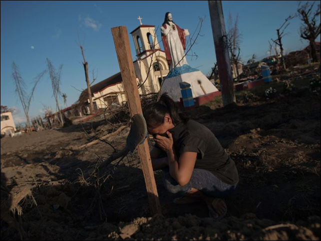 Marelom Cassanares, 37, who has five children and no home, cries at the grave of her husband in the aftermath of Super Typhoon Haiyan in Palo, on the outskirts of Tacloban, 16 November 2013. Photo: Nicolas Asfouri / AFP / Getty Images