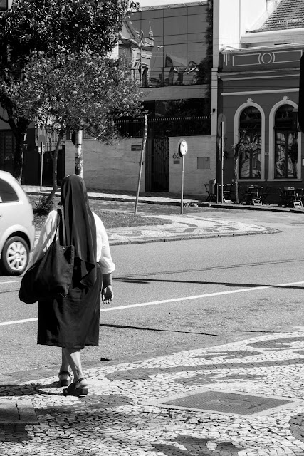 religiosa na calçada prestes a atravessar a rua