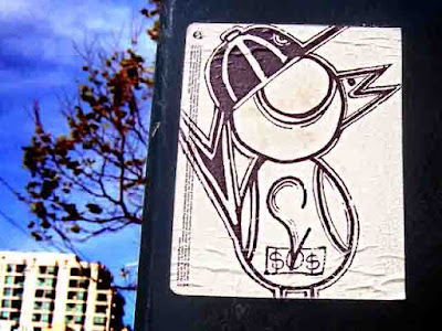 a graffiti bird wearing a baseball cap and holding money on a sticker somewhere in San Francisco