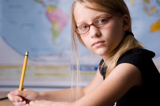 Child in glasses studying and learning