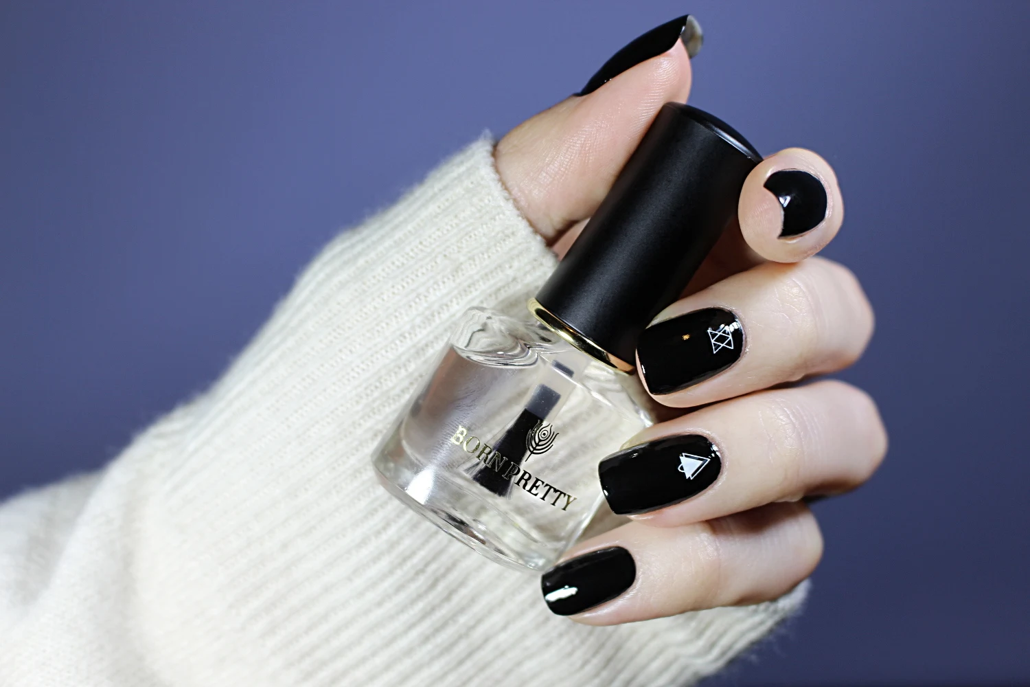 a close-up of a basic black manicure with glossy finish on a short, natural nails