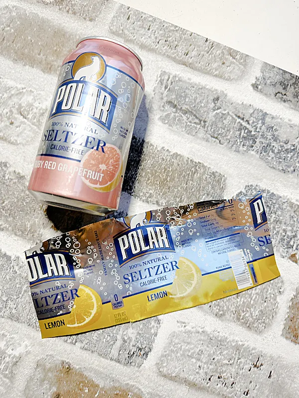 seltzer cans on brick background
