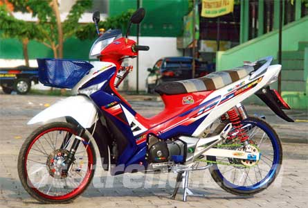 Foto Modifikasi Honda Supra Rombakan dengan kelir bendera belanda tersebut, yang disembur merata dan di tutup dengan stiker Wave i 125 atau motor supra X 125 versi Thailand. Pelek dibikin dua warna dengan Osaki merah dibagian depan dan Takasago biru dibagian belakang.