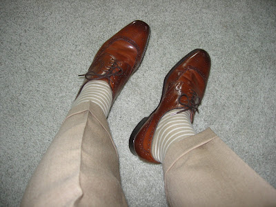 Striped socks bluchers and a tan nailhead suit Above the waist a yellow 
