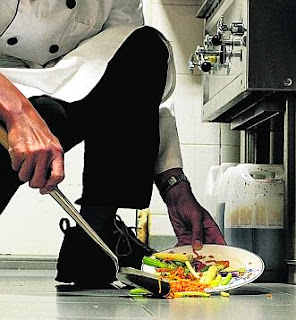 Chef scooping food into a plate