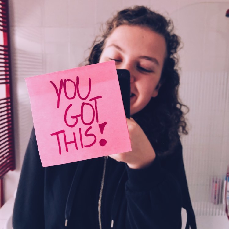 Spiegel selfie met een positieve boodschap: 'you got this', geschreven op een roze post-it op de voorgrond.