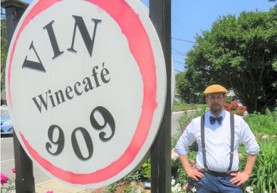 Man next to VIN909Winecafe sign.