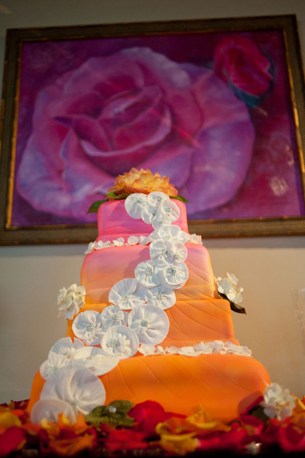 Stunning four tier square wedding cake with an orange to pink gradient and 