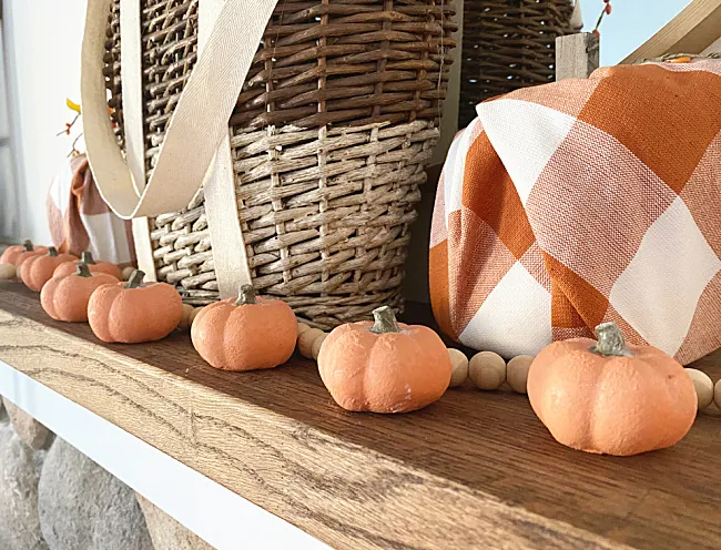 row of mini pumpkins on the mantel