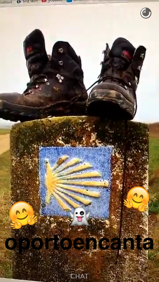 Duas botas de caminhada em cima de um marco do Caminho de Santiago