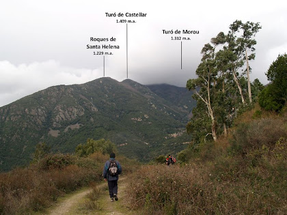 Vistes de les Roques de Santa Helena i del Turó del Castellar, i enmig de la boira el Turó de Morou, des de la Pedrera de la Meca