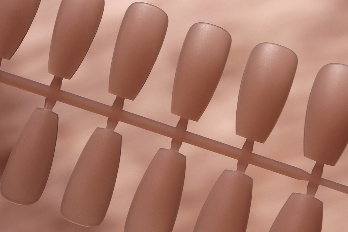 macro close-up of gel nail tips in nude color