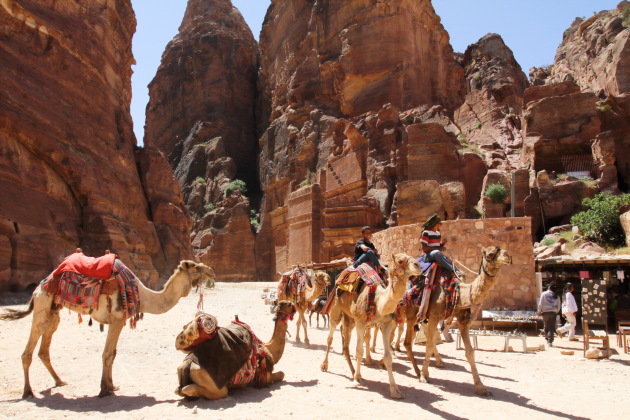 Camels and their riders at the entrance to the street of facades, Petra, Jordan