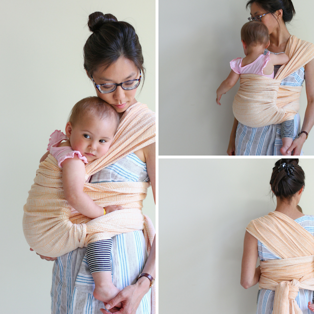 [Three image collage of a tan skin bespectacled Asian woman with dark brown hair up. She's wearing a blue and gray striped linen dress. Toddler is worn on her frontish-hip in a woven wrap with an undyed combed cotton warp and a mercerized orange weft in a modified herringbone pattern. The carry is one shouldered and shows off both sides of the wrap. It's double knotted at the waist in the back. They're in front of a beige wall. Left image is a vertical rectangle from the side of the toddler resting head on Mama's chest and Mama's looking down the toddler foot cradled in her hand. Top right image is square and from the front with both toddler and Mama not facing the viewer. Bottom right image is square and from the back.]