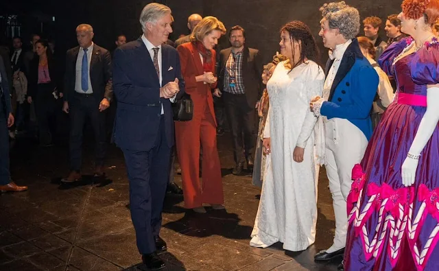 Queen Mathilde wore an orange brown two-button blazer suit jacket by Dries Van Noten. Les Miserables novel by Victor Hugo