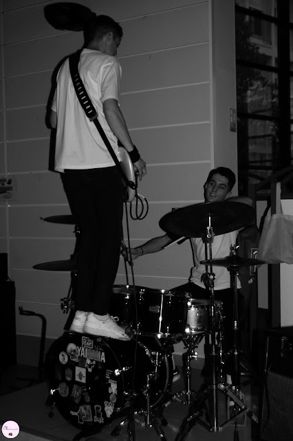 photographie prise lors d'un concert, ennoir et blanc, guitariste et batteur 