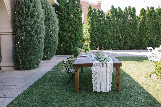 vineyard wood head table with a lace runner and olive garland for a classic white garden wedding in Utah