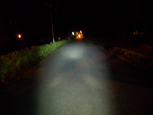 Bicycle headlamp IXON IQ on a dark narrow road