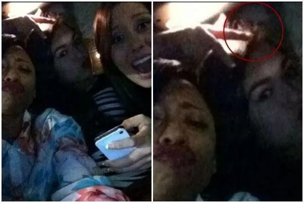 The figure of a creepy ghost hitching a ride in the selfie photo of this group of women