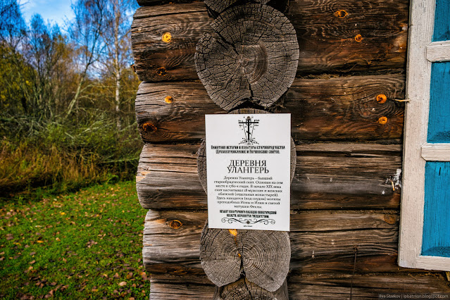 Памятная табличка на углу деревянного сруба