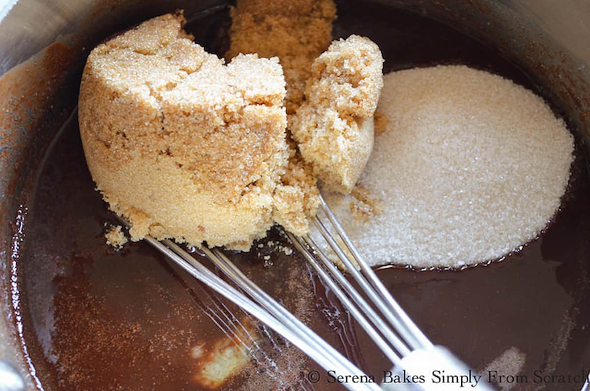 Brown Sugar and Granulated Sugar added to melted chocolate mixture in a stainless steel pan.