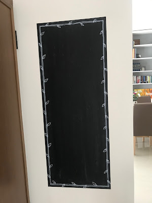 Chalkboard on wall with hand drawn leaves frame