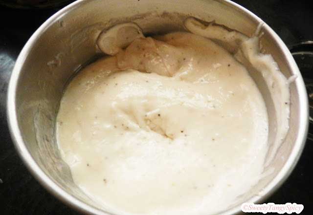 A close-up view of bananas being blended into a smooth puree in a mixer grinder.